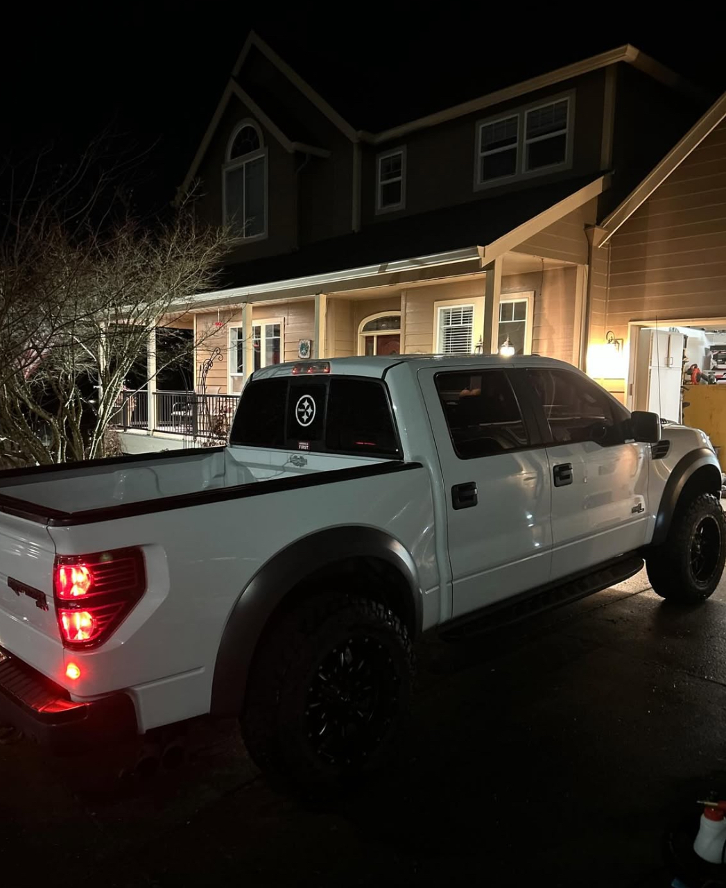 White Ford Raptor detailed at night showing glossy paint and dressed tires